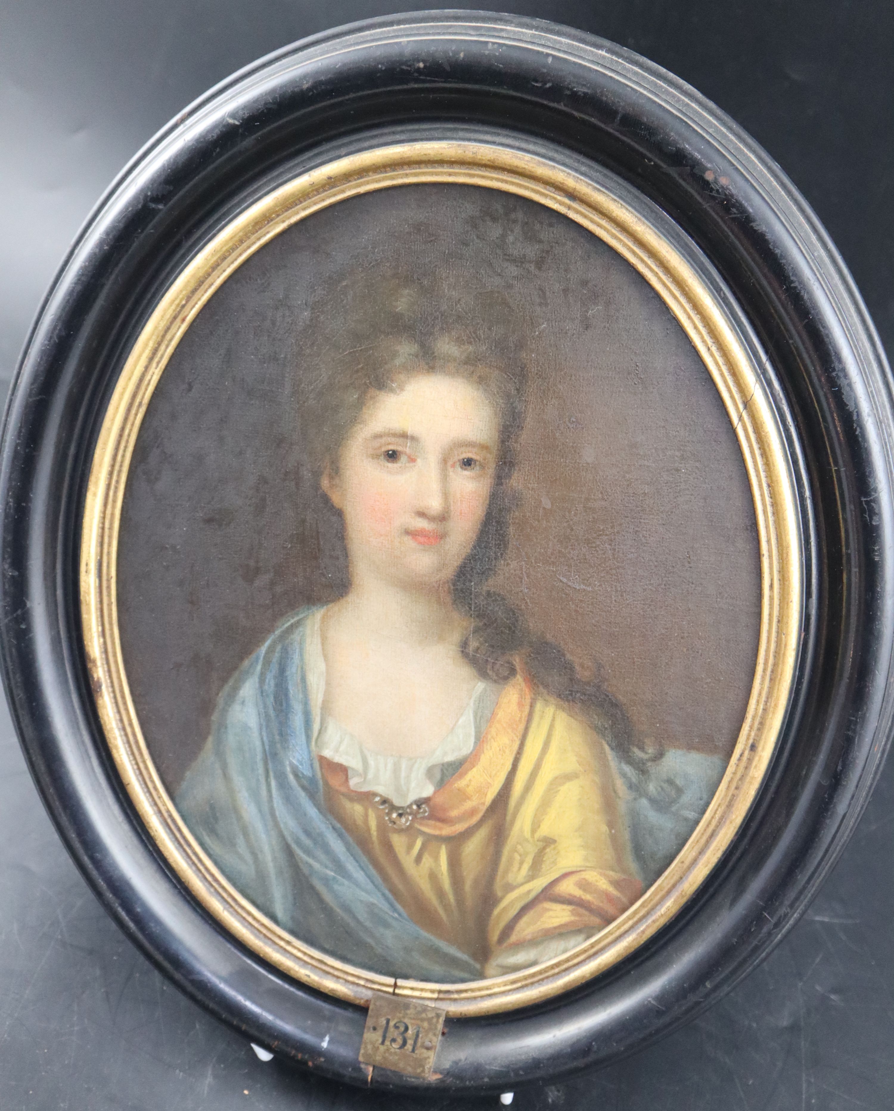 Follower of Michael Dahl (1659-1743), Half length portrait of Alice Wyndham (d.1723), wearing a yellow dress and blue cloak, oval, 28 x